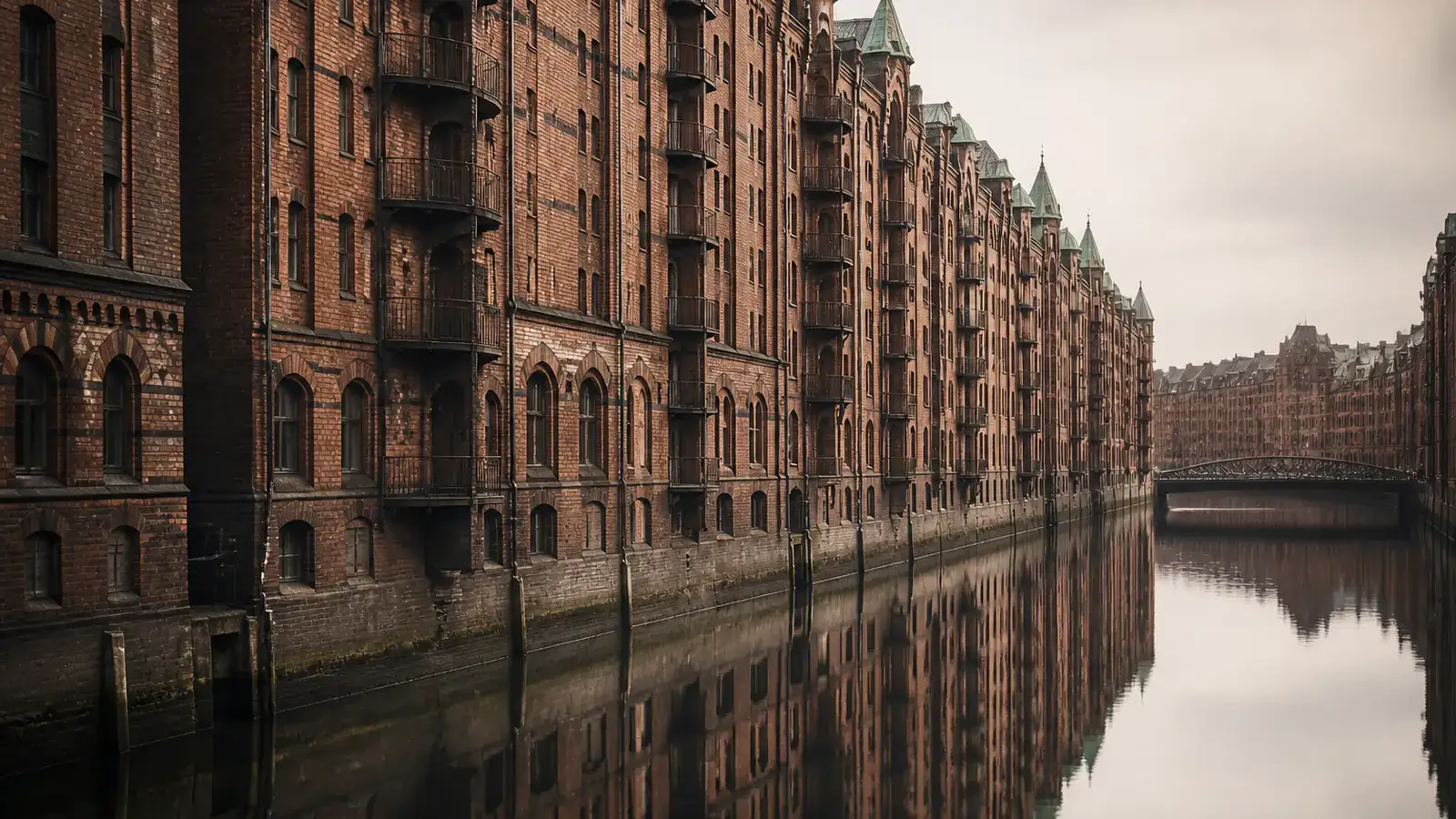 Die Backsteinfassaden der Hamburger Speicherstadt spiegeln sich im stillen Kanalwasser